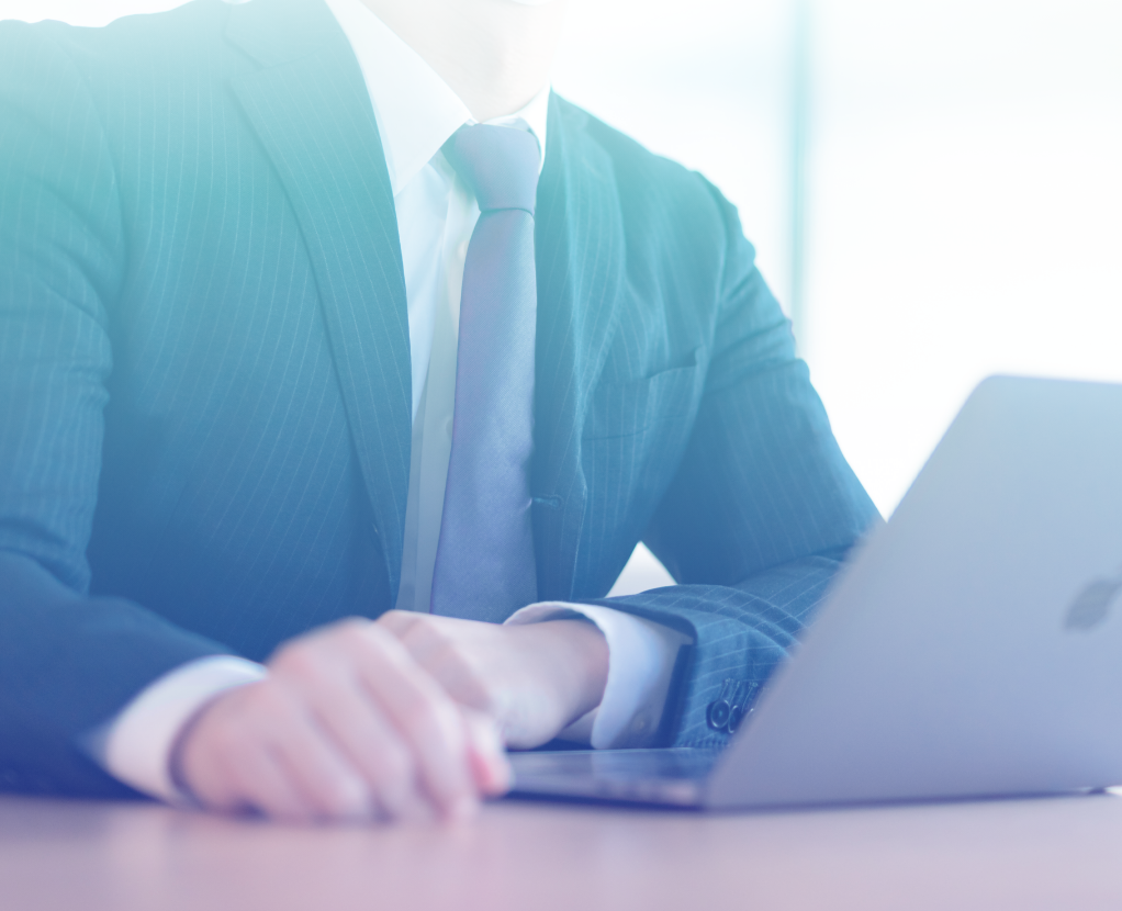 ノートパソコンを開きメモを取るビジネスマンの手元